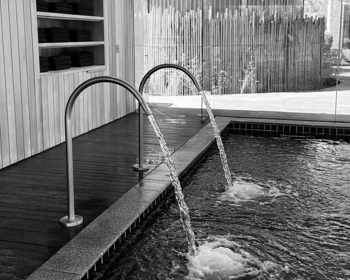 Ruhiger Spa-Pool mit Wasserfontänen und Holzverkleidung