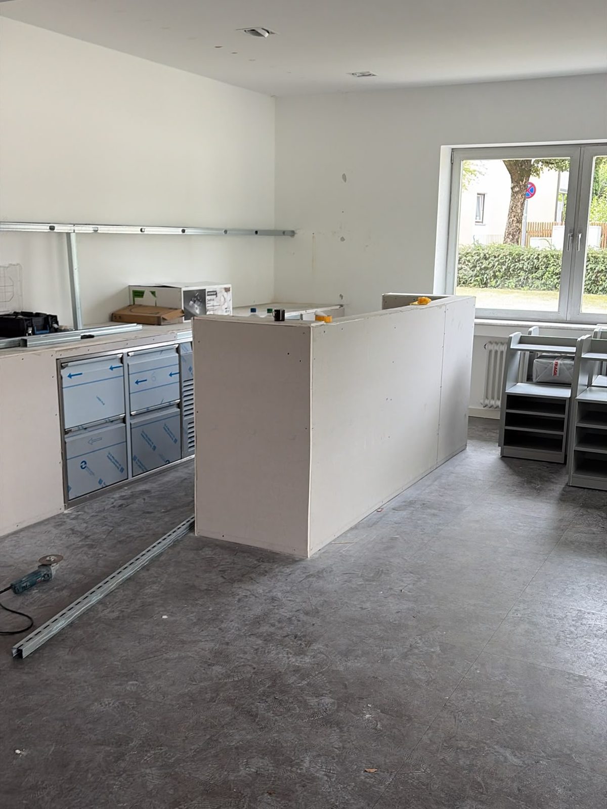 Der Empfangsbereich der Lounge: Tresen mit eingebauter Technik, dahinter montierte Wandschienen