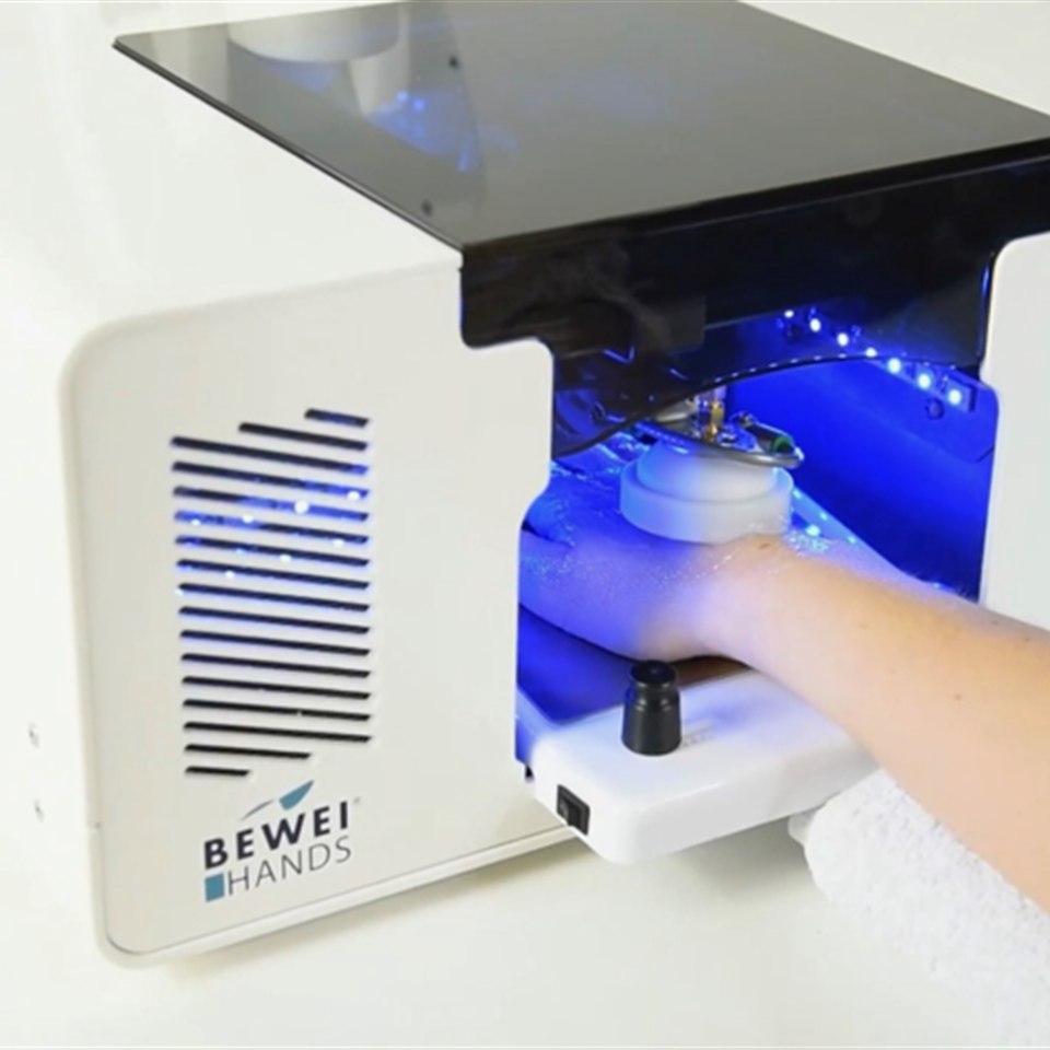 BEWEI Hands im Einsatz: Hand im BEWEI Hands Gerät mit blauem Anwendungslicht